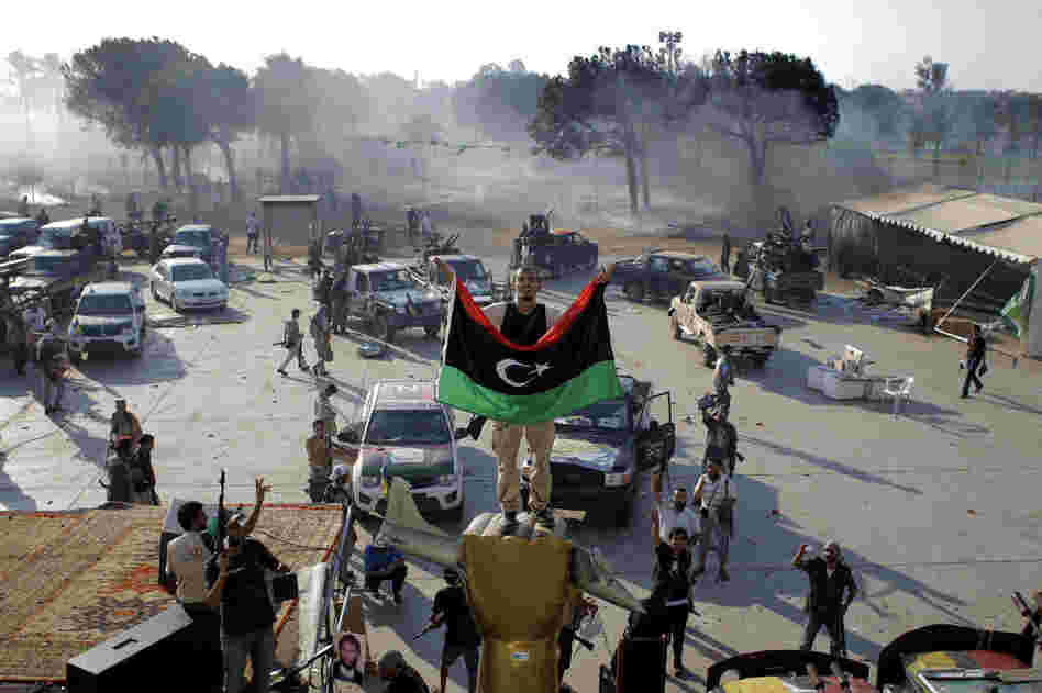 A Libyan rebel stands on a monument in Gadhafi's main compound. 