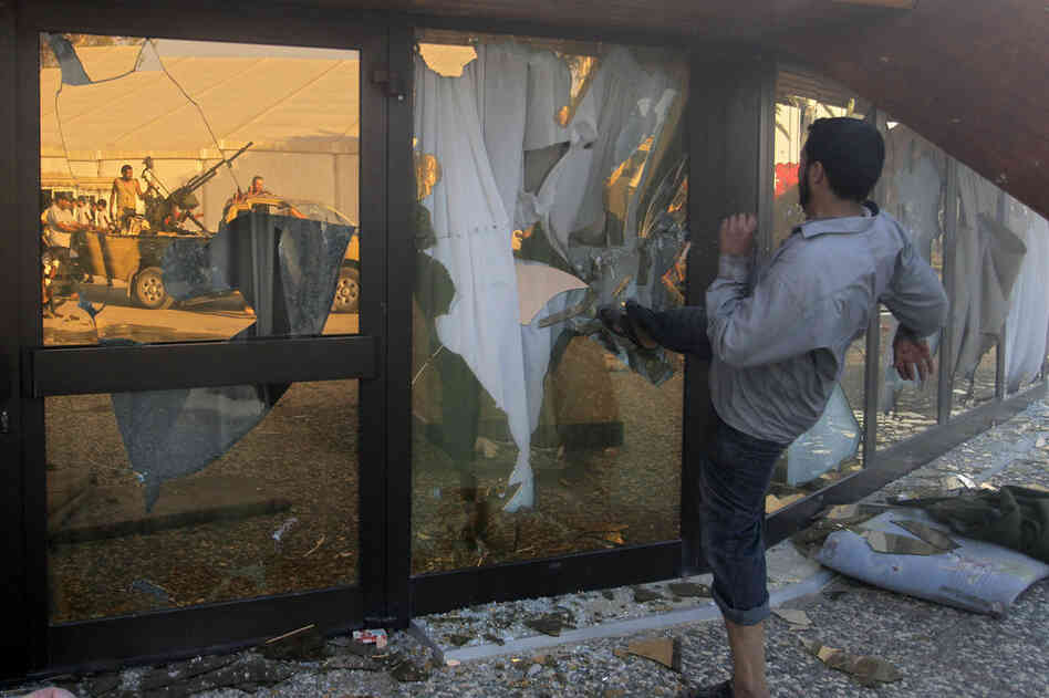 A Libyan rebel breaks the glass of Moammar Gadhafi's main compound in Tripoli on Tuesday. 
