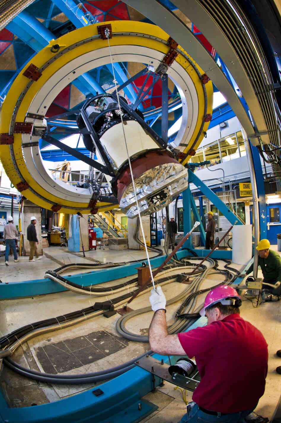 Workers test the fitting of the camera on a simulator device at Fermilab, outside Chicago. The camera will be installed on the Blanco telescope high in the Chilean mountains.
