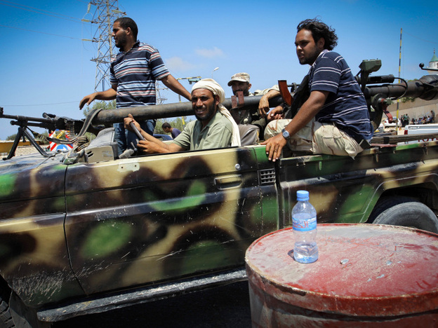 Libyan rebel fighters sped towards the front line of fighting in the village of Al-Mayah, just west of Tripoli, on Sunday.