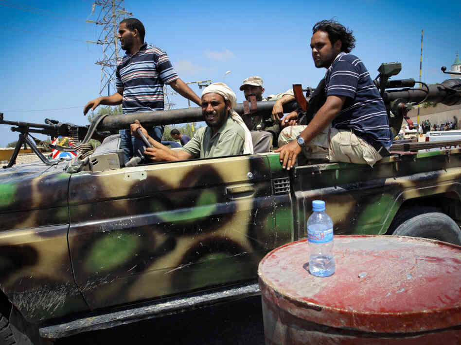Libyan rebel fighters sped towards the front line of fighting in the village of Al-Mayah, just west of Tripoli, on Sunday.