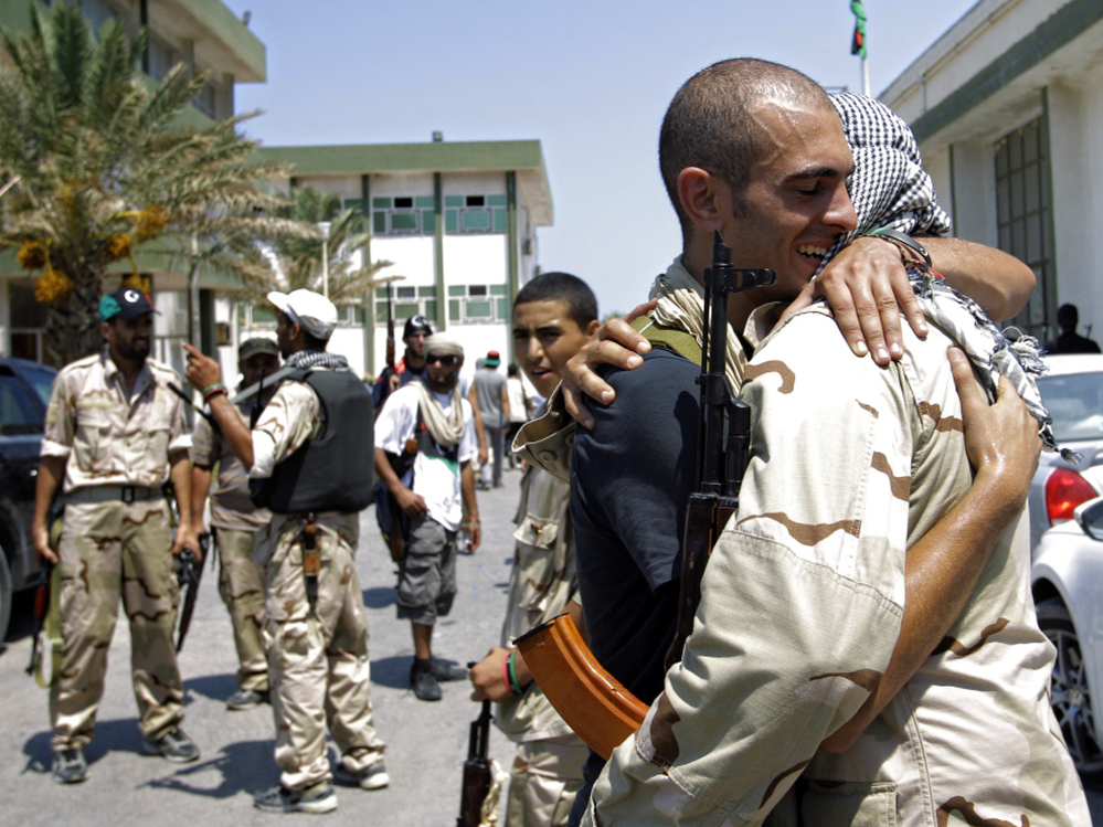 Libyan rebels embraced Monday at the former female military base in Tripoli after opposition fighters raced into the capital in a lightning advance the day before.