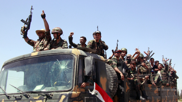 Syrian soldiers shout slogans in support of President Bashar Assad Aug. 10 as they withdraw from the city of Hama after a 10-day military operation to quell pro-democracy protests. This photo was taken during a government-guided tour.