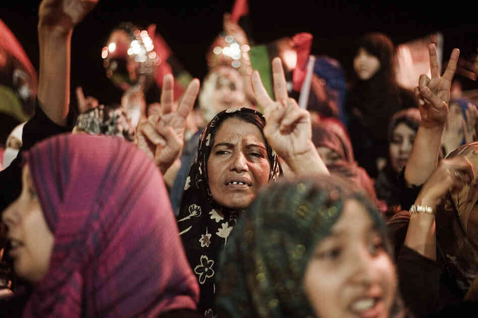 A Libyan woman flashes the V-sign for victory as people celebrate the end of Gadhafi's 42-year rule in the eastern city of Benghazi. 