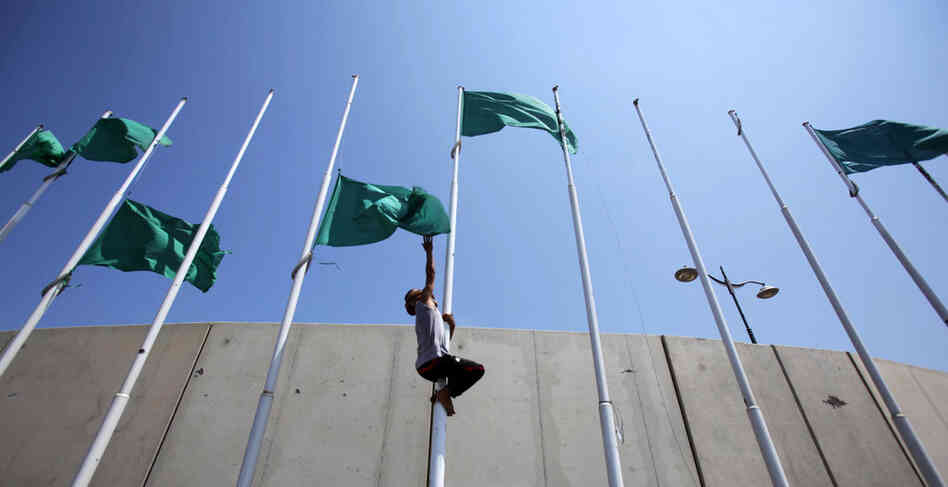Libyan rebels remove the green flags from poles at the Abu Salim square in Tripoli on Aug. 26 after the opposition forces announced the transfer of their leadership to the capital. 