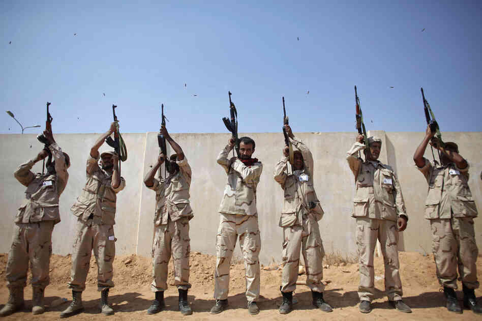 Rebel fighters shoot to the sky during a funeral in Benghazi. 