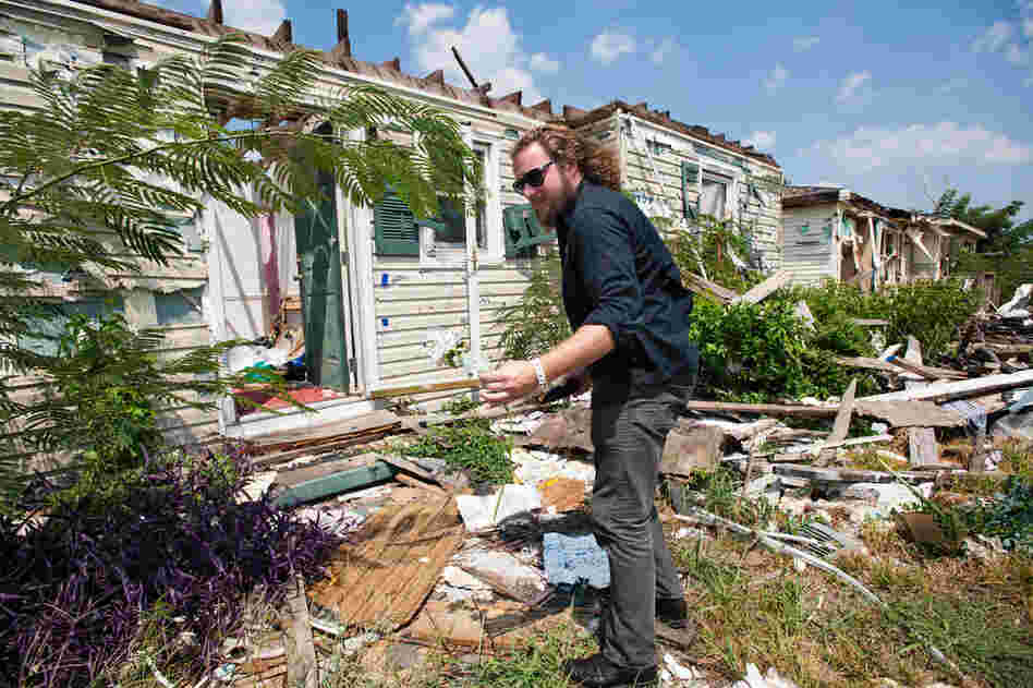 Jim James of My Morning Jacket pulls a silk rose from the rubble of a house destroyed by a tornado in Tuscaloosa, Ala., Aug. 19."Anytime you do an event that's associated with something else, it takes on a different place in your head than a normal event," said James during a tour of Tuscaloosa's ravaged neighborhoods. "Seeing what happened definitely makes it more emotional. You think a...