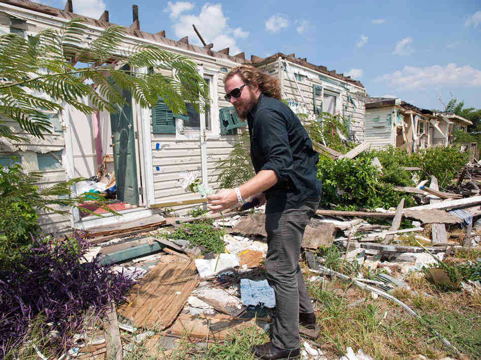 On August 19, Jim James of My Morning Jacket pulls a silk rose from the rubble of a house in Tuscaloosa that was destroyed by a tornado in April. On August 19, Jim James of My Morning Jacket pulls a silk rose from the rubble of a house in Tuscaloosa that was destroyed by a tornado in April.