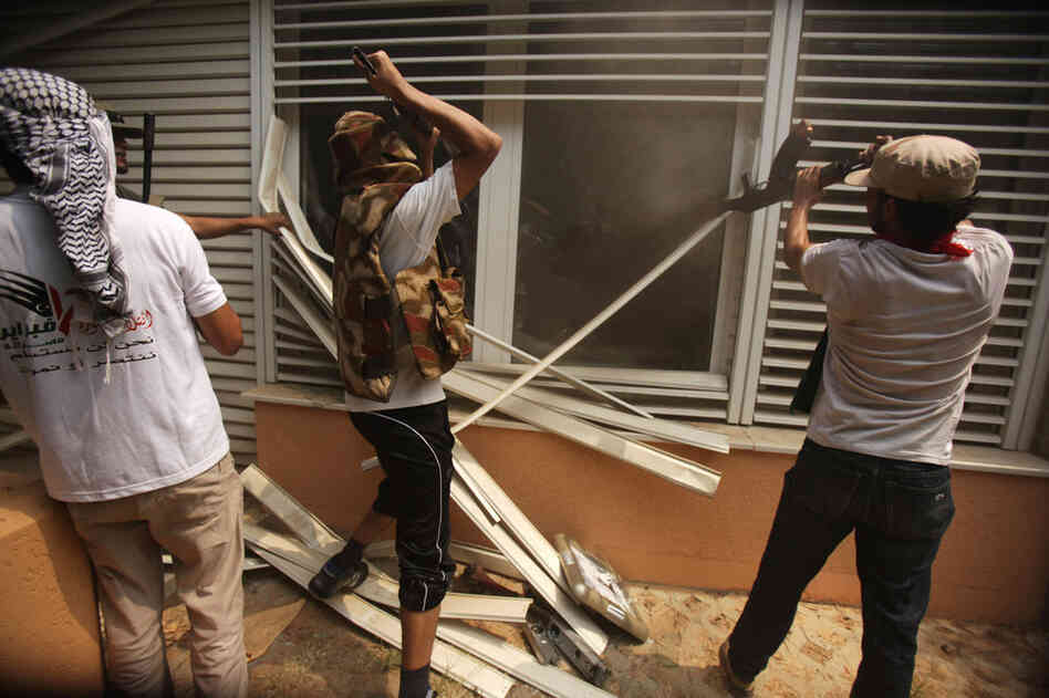 Rebels break into a living room at Gadhafi's compound. 