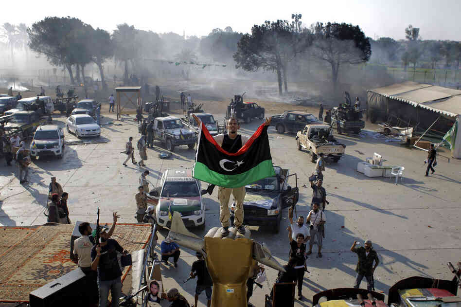 A Libyan rebel stands on a monument in Gadhafi's main compound. 