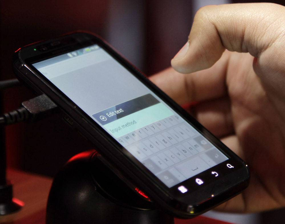 A buyer tests a Motorola Droid phone in this photo from January. Google purchased Motorola for $12.5 billion, gearing up in a patent war that has seen corporations try to pummel their competitors.