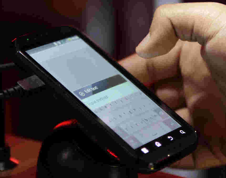 A buyer tests a Motorola Droid phone in this photo from January. Google purchased Motorola for $12.5 billion, gearing up in a patent war that has seen corporations try to pummel their competitors.
