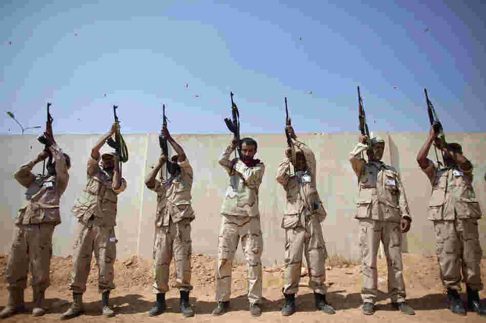 Rebel fighters shoot to the sky during a funeral in Benghazi. 