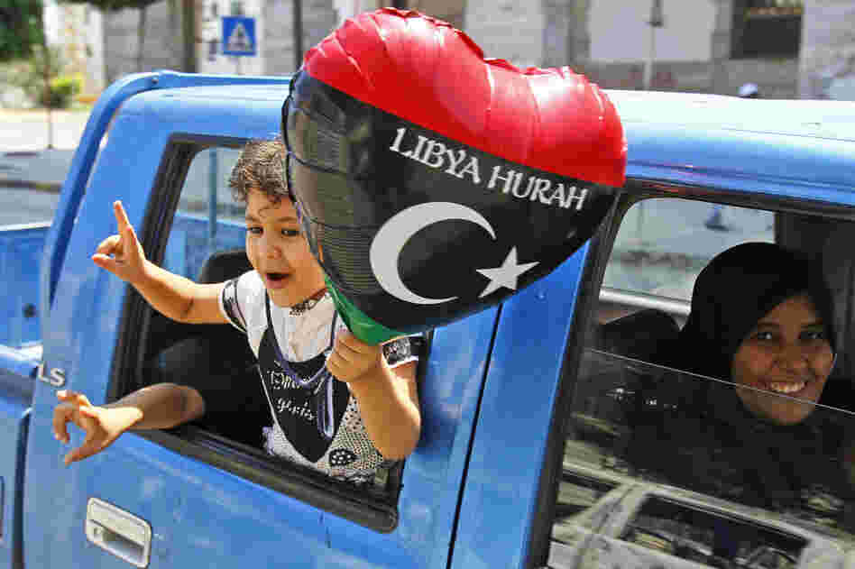 A Libyan family shows support for the rebel forces as they drive in a safe district in Tripoli. 