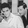 Jerry Leiber (right) looks over Elvis Presley's shoulder at the sheet music for "Jailhouse Rock" in Los Angeles in 1957. His songwriting partner Mike Stoller stands to the left.