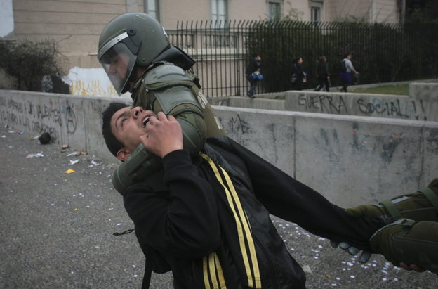 Riot police detain a demonstrator on the second day of a national strike in Santiago, Chile on Thursday.