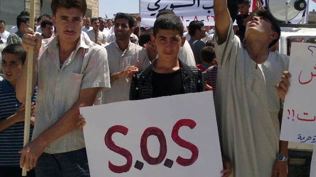 In an image taken by a citizen journalist and provided by Shaam News Network, protesters in the Syrian village of Maaret Harma in Edlib province march against the regime of President Bashar Assad,  Aug. 26. The government has banned most foreign journalists in the country and is continuing a brutal crackdown on anti-government activists.