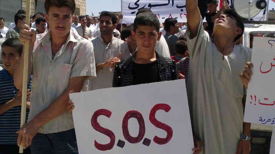 In an image taken by a citizen journalist and provided by Shaam News Network, protesters in the Syrian village of Maaret Harma in Edlib province march against the regime of President Bashar Assad,  Aug. 26. The government has banned most foreign journalists in the country and is continuing a brutal crackdown on anti-government activists.