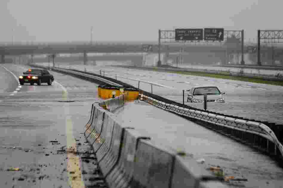 An abandoned car sits half-submerged in floodwaters on a southbound lane of the New Jersey Turnpike near exit 12 in Carteret, N.J. 