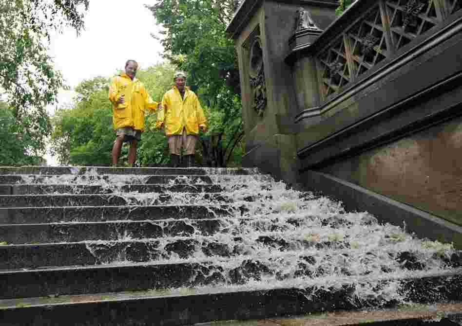 Jimmy Kaplow (left) and David Korostoff watch as water in New York City's Central Park flows down the steps as the tropical storm passes through the city on Sunday. 