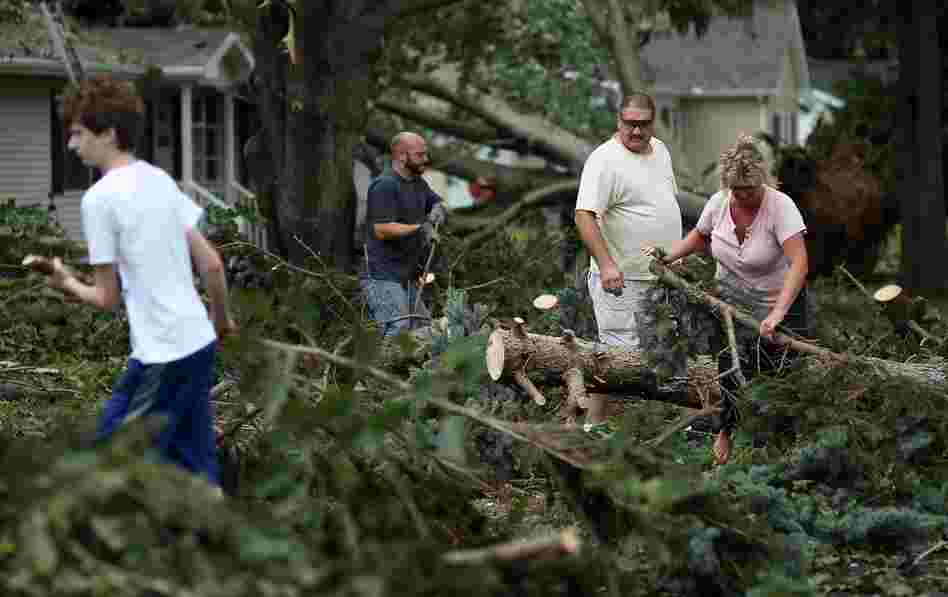 Residents clear debris from downed trees after a tornado spawned by Hurricane Irene touched down, on Sunday in Lewes, Del. 