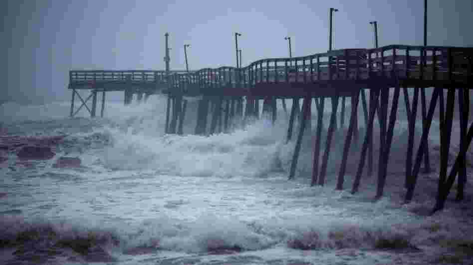Waves crash into Avalon Pier as Hurricane Irene strikes the Outer Banks in Kill Devil Hills, N.C. earlier today.