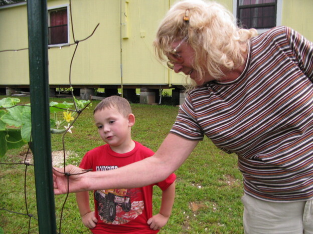 Pamela Landry and her grandnephew, Jason, pick tomatoes in the backyard of her shotgun house. She stayed in Picayune, Miss., after Katrina in part because of her family roots in the area.