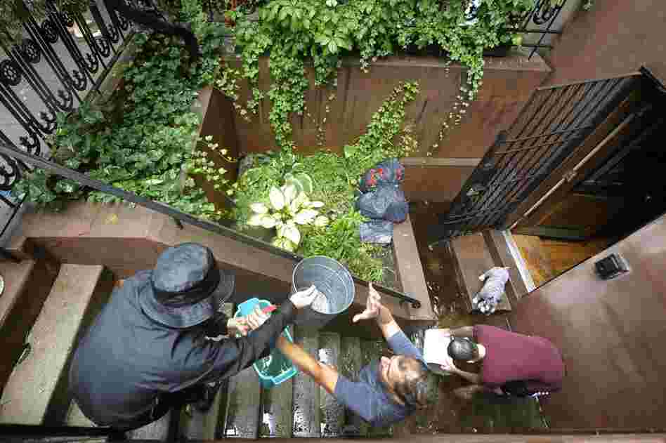 People form a bucket brigade to bail water out of a flooded Chelsea apartment in New York on Sunday. 