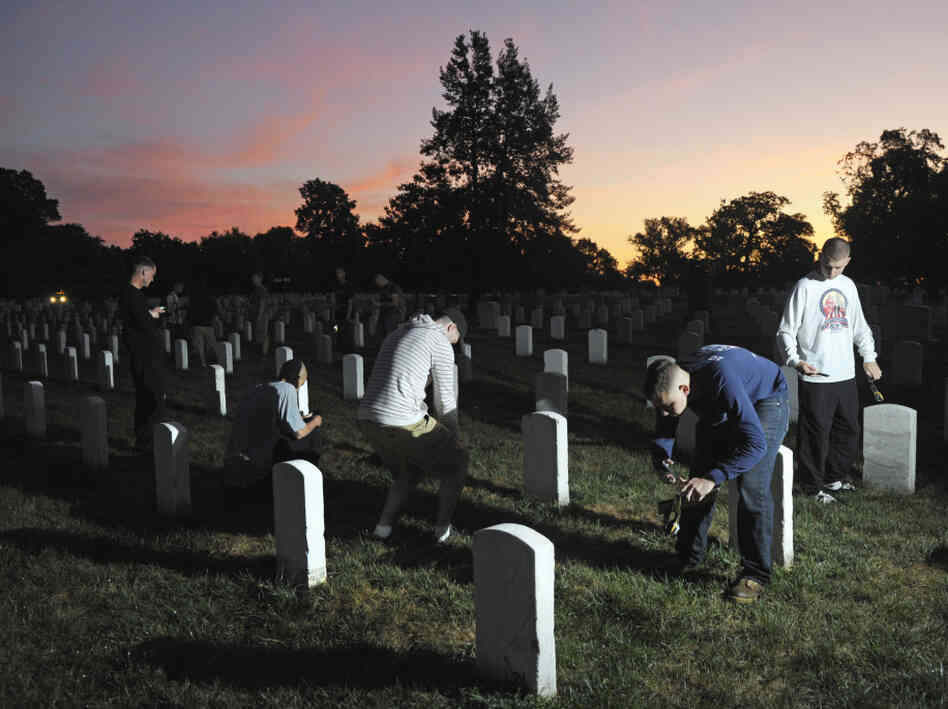 The sun rises over Section 15 at Arlington National Cemetery as soldiers from the Army Old Guard photograph headstones on Aug. 24. Their work is part of a task force to photograph and catalog nearly 220,000 grave markers and the columbarium niches of more than 43,000 sets of cremated remains at Arlington.