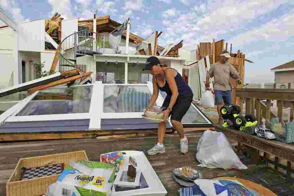 Denise Robinson and Rich Brown clear out belongings from Robinson's storm-damaged beach home in the Sandbridge area of Virginia Beach, Va. 