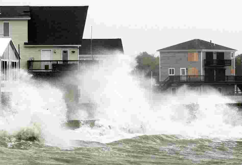 Waves crash along a seawall as the tropical storm, downgraded from a hurricane, slammed into Fairhaven, Mass., on Sunday. 