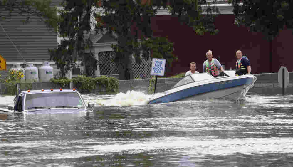 A motorboat passes a submerged pickup truck on Main Street in Washingtonville, N.Y., on Sunday following heavy rains from Tropical Storm Irene. 