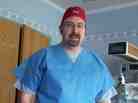 Jeff Pike puts on scrubs as his wife, Andrea, is taken in to surgery for a C-section.