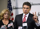 Texas Gov. Rick Perry, with wife Anita, gestures as he answers a question at a news conference in Tulsa, Okla., Monday, Aug. 29, 2011. Texas Gov. Rick Perry, with wife Anita, gestures as he answers a question at a news conference in Tulsa, Okla., Monday, Aug. 29, 2011.