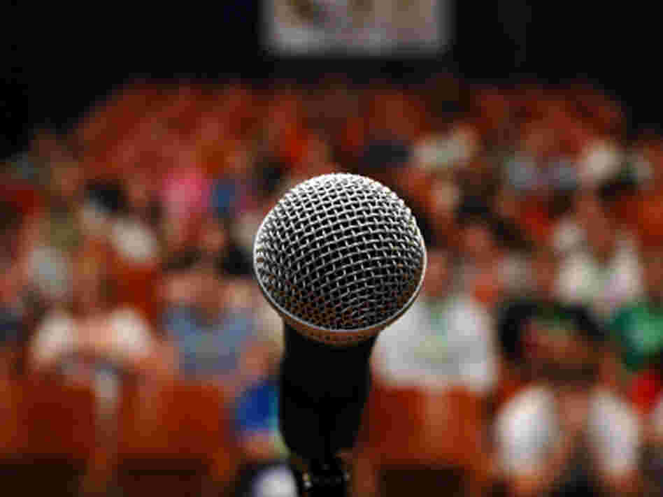 a microphone with an audience behind it a microphone with an audience behind it