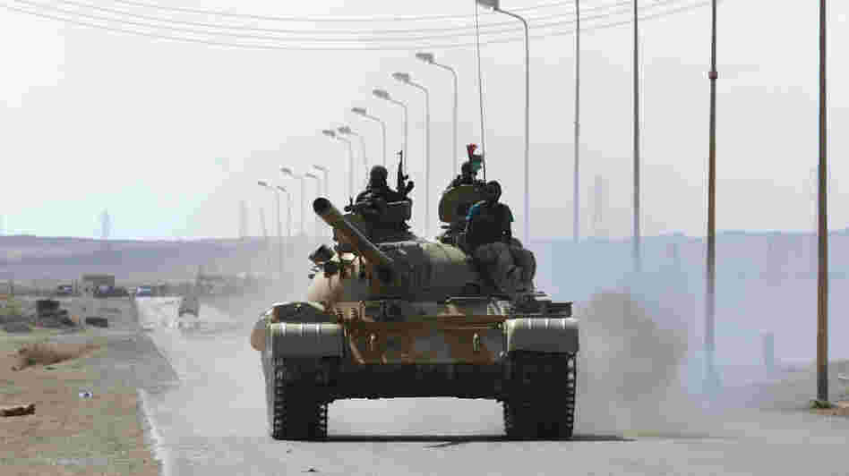 Libyan rebel fighters advance in their tank about 60 miles east of the town of Sirte on Tuesday. Sirte is Moammar Gadhafi's hometown and the last bastion of his loyalist forces.