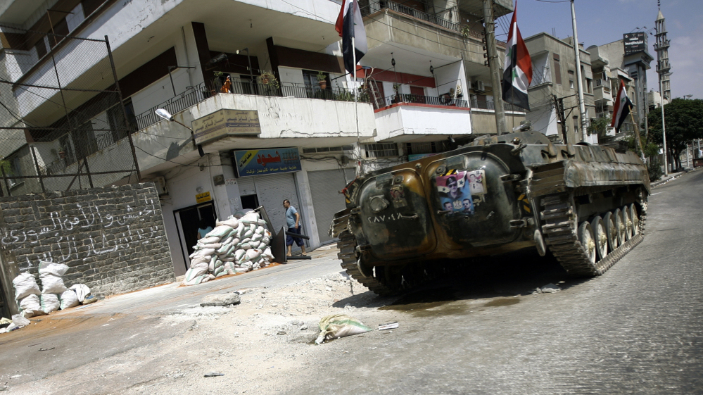 A Syrian military tank takes position in a residential street in the central city of Homs Monday. Government troops reportedly are defecting to join the activists.
