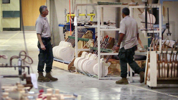 Federal investigators look through the workshop at the Gibson Guitar factory during a raid on the Memphis facility last week.