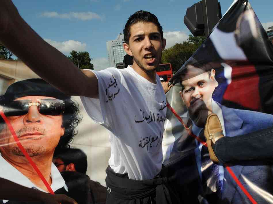 Activists hold pictures of Syrian president Bashar Assad and fallen Libyan strongman Moammar Gadhafi as they take part in a demonstration on Aug. 28, 2011 at Taksim Square in Istanbul. Dozens of Syrian dissidents based in Turkey gathered in downtown Istanbul to protest the regime of Assad. Activists hold pictures of Syrian president Bashar Assad and fallen Libyan strongman Moammar Gadhafi as they take part in a demonstration on Aug. 28, 2011 at Taksim Square in Istanbul. Dozens of Syrian dissidents based in Turkey gathered in downtown Istanbul to protest the regime of Assad.