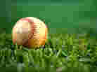 A baseball in the grass.