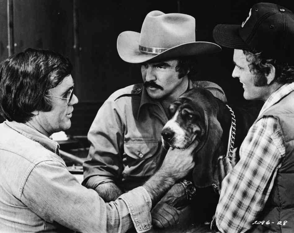 Director Hal Needham lines up a shot with actors Burt Reynolds, Jerry Reed and Happy the dog on the set of the 1977 movie Smokey and the Bandit.