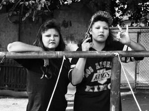 BooBoo (right) flashes a Playboys gang hand sign, 1993.