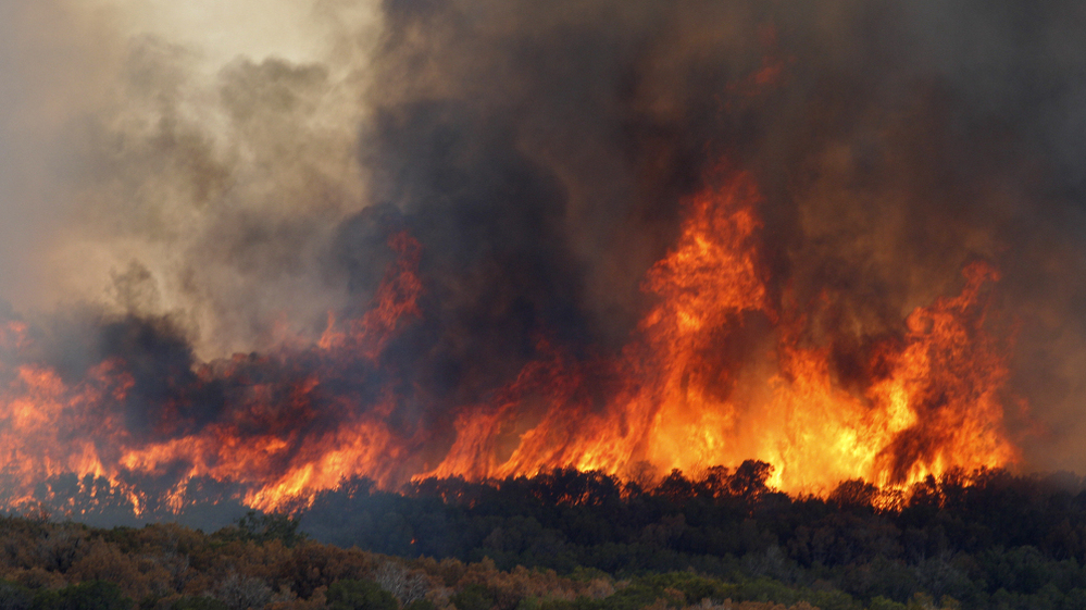 A wildfire roars through dry trees near  Possum Kingdom Lake, Texas, Wednesday, Aug. 31, 2011.