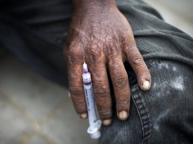 A Pakistani drug addict holds a syringe after injecting heroin on a street in "Kala Pull" (Black Bridge) district of Karachi on July 25, 2011.