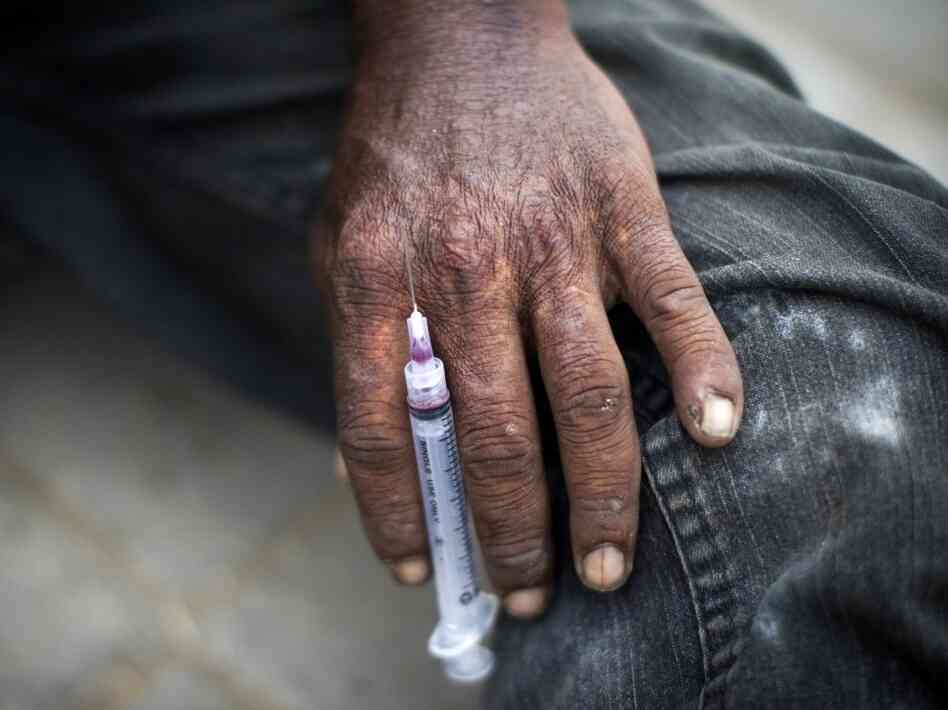 A Pakistani drug addict holds a syringe after injecting heroin on a street in "Kala Pull" (Black Bridge) district of Karachi on July 25, 2011.
