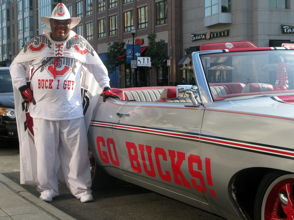 John Chubb, aka Buck I Guy, standing next to his vintage 1970 Chevy Impala — his "Buck I Guy Mobile."