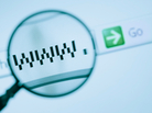 Magnifying glass enlarges a URL on a computer screen. Magnifying glass enlarges a URL on a computer screen.