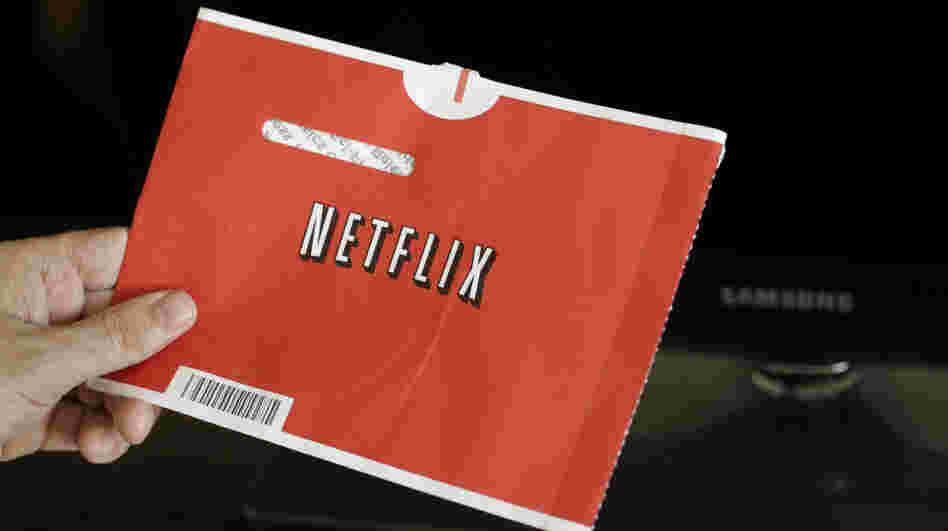 A Netflix customer holds up a movie envelope.