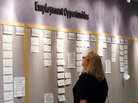 A woman looks at posted employment opportunities at a Denver Employment office. A woman looks at posted employment opportunities at a Denver Employment office.