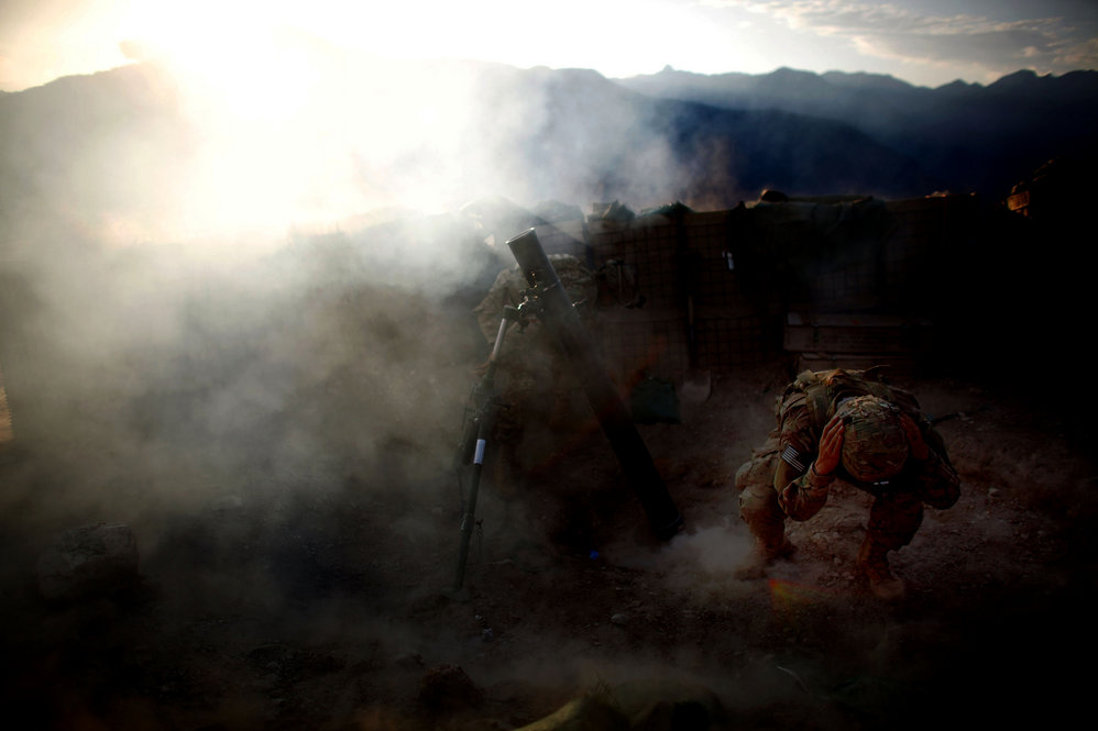 Pfc. Jaworski covers his ears as an explosive round is fired.